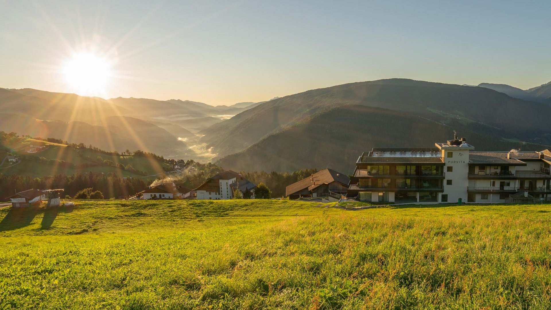 Hotel Purvita bei Sonnenaufgang mit Blick auf das Pustertal, Meransen und die Dolomiten – Südtirol