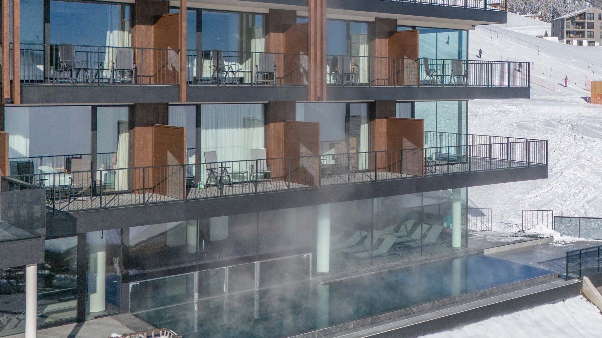 Winteransicht des Hotel Purvita in Meransen mit großen Zimmern und Panoramafenstern, Infinitypool und Skilift im Hintergrund – Ski-in/Ski-out Hotel in Südtirol mit Wellness, Bergblick und Winterurlaub