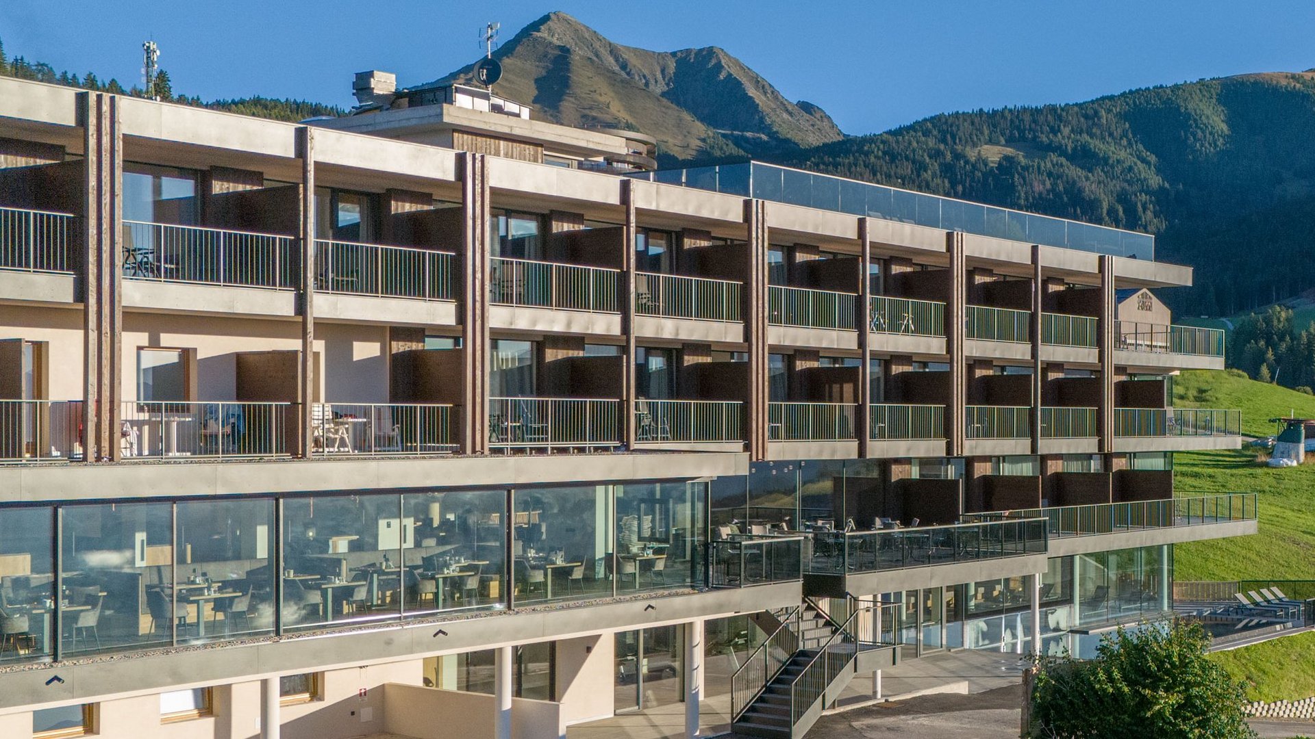 Hotel Purvita im Sommer in Meransen mit Panoramaspeisesaal, Infinitypool, Wiesen und Blick auf den Gitschberg – Sommerurlaub, Bergpanorama und Wellness in Südtirol